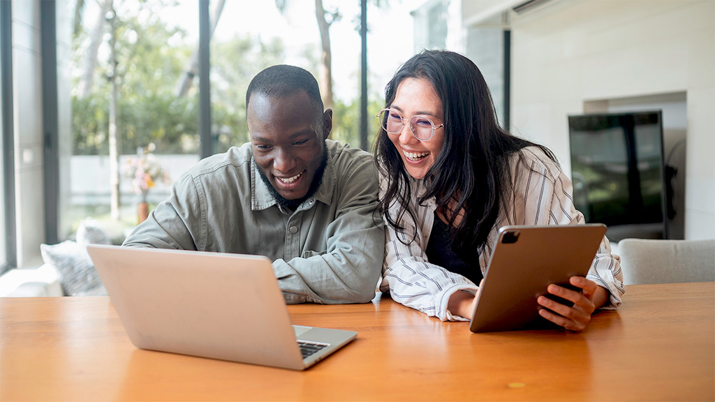 Man and woman at a desk and using a computer.