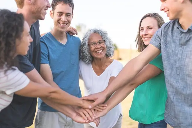 a group of people putting their hands together