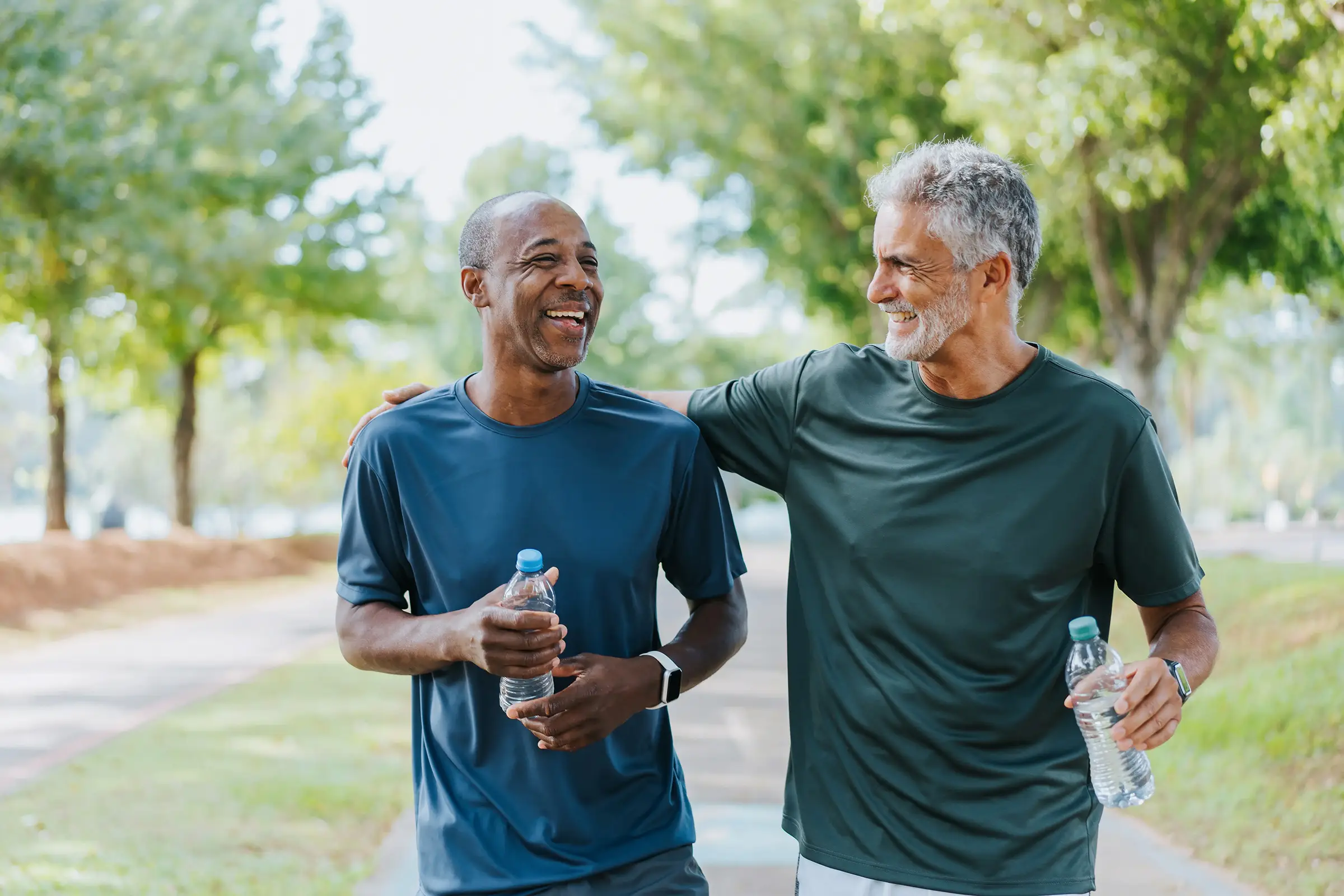 two men holding water bottles and smiling