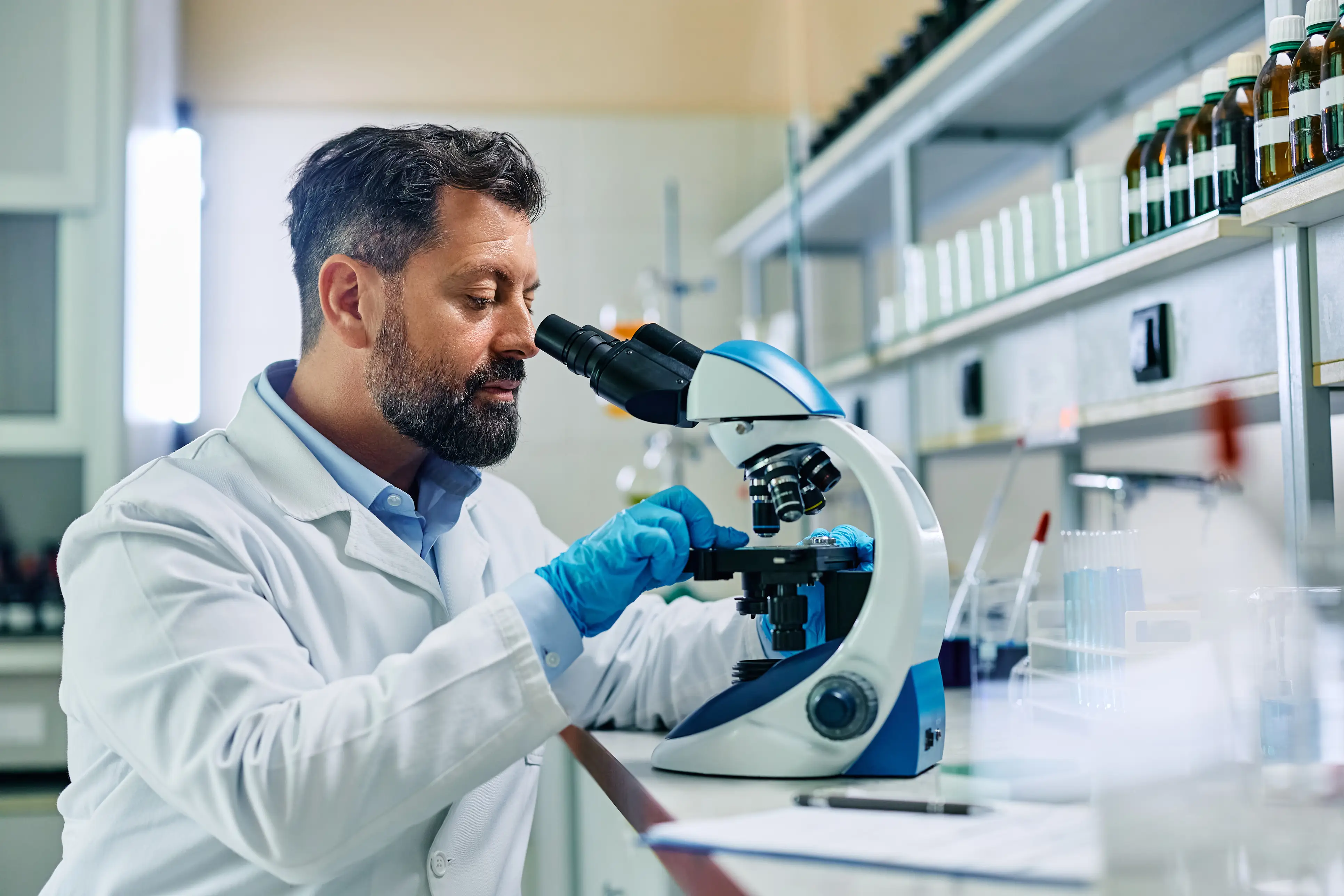 a man looking through a microscope