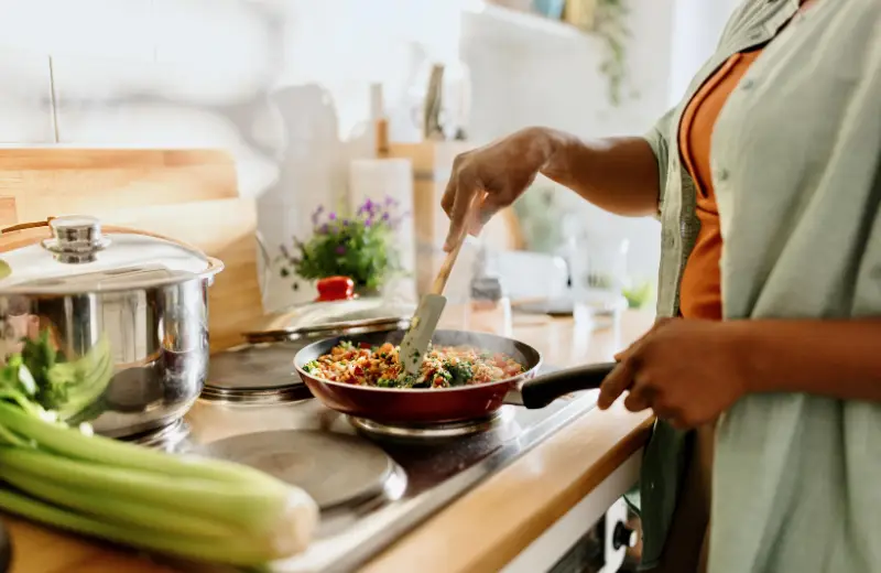 a person cooking food in a pan