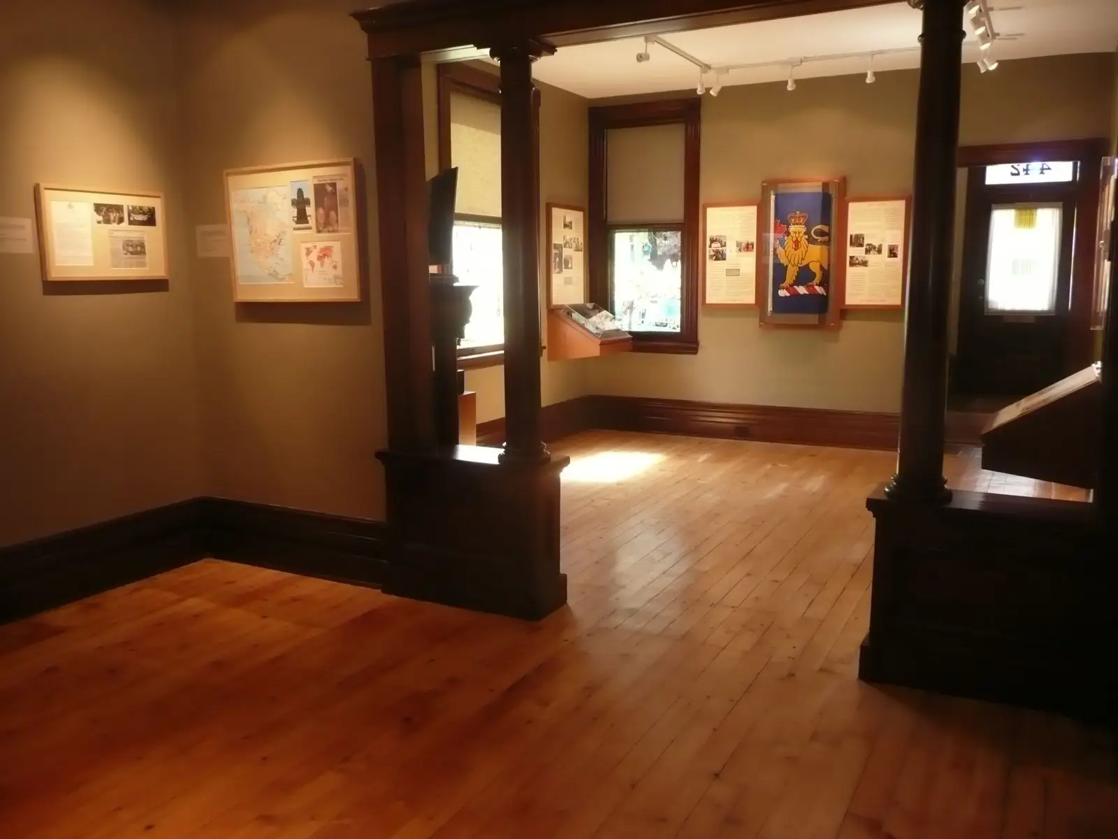 a room with wood floors and framed pictures