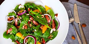 a bowl of salad with onions and greens