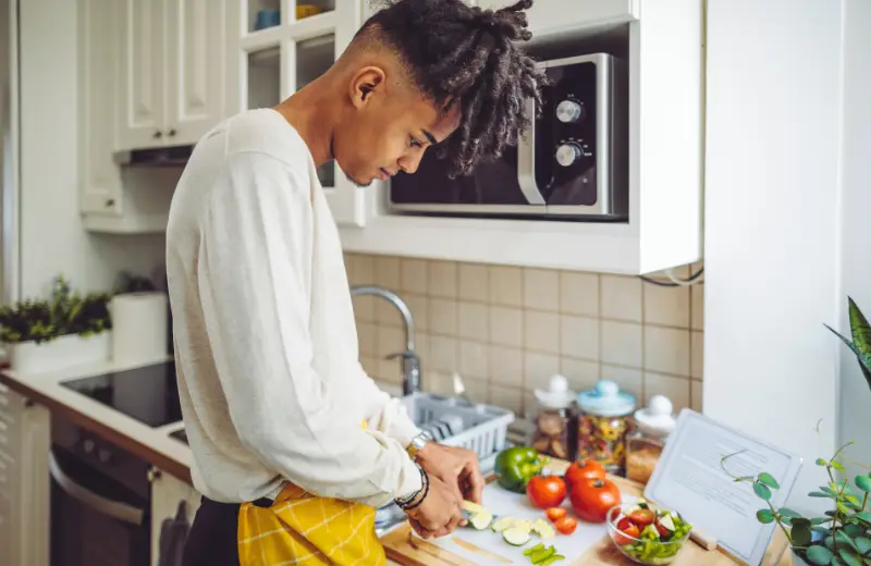 a man cutting vegetables in a kitchen