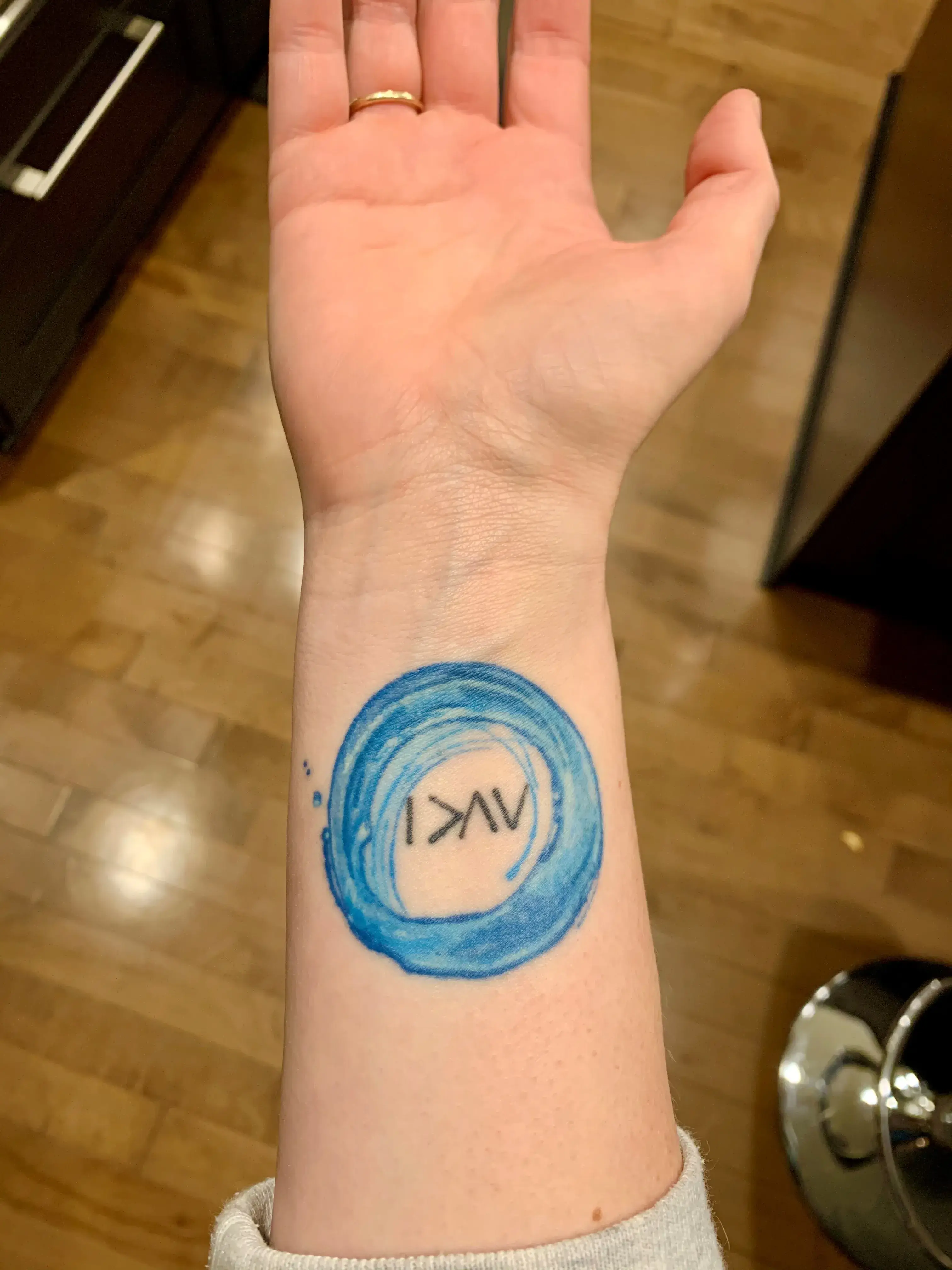 a blue circle with a tattoo on a wrist