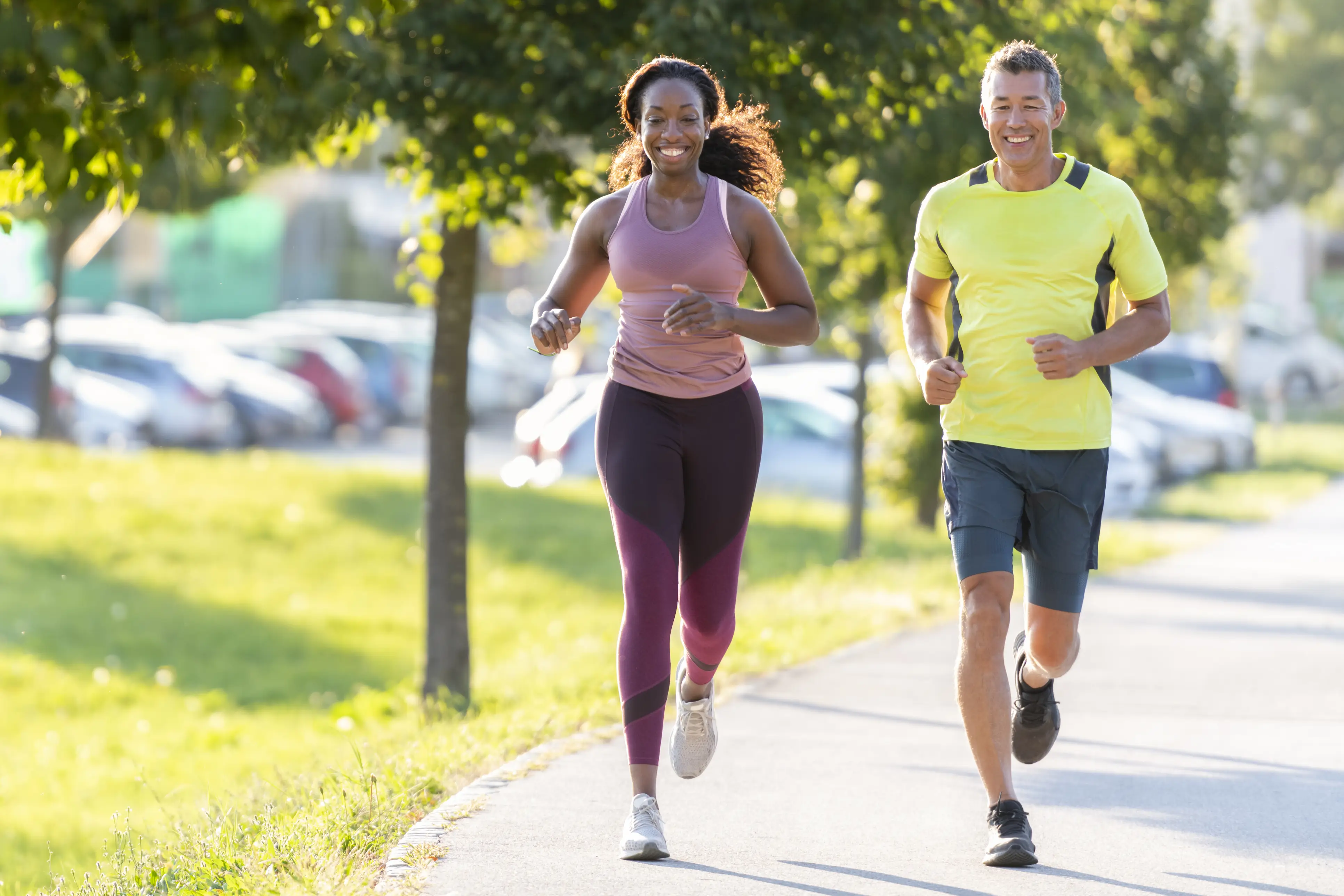 a man and woman running on a sidewalk