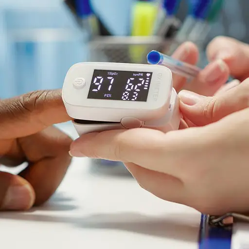 a person's hand holding a fingertip device