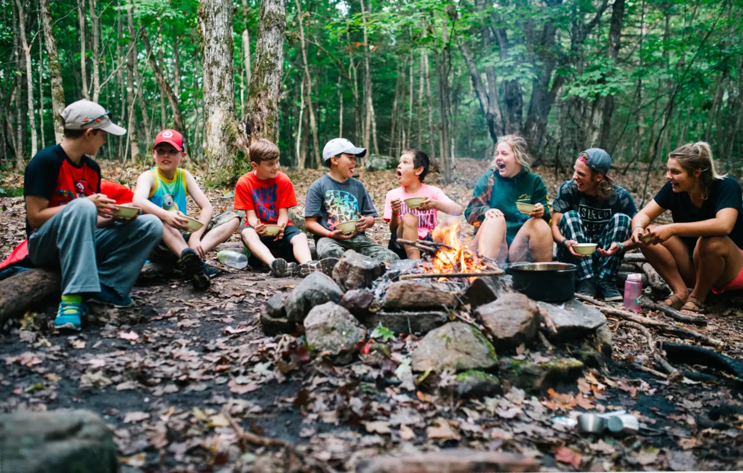 a group of people sitting around a campfire