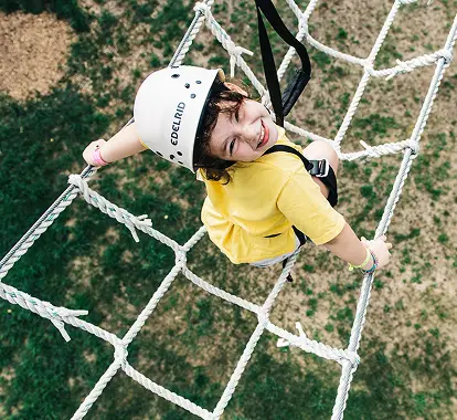 a child climbing a rope net