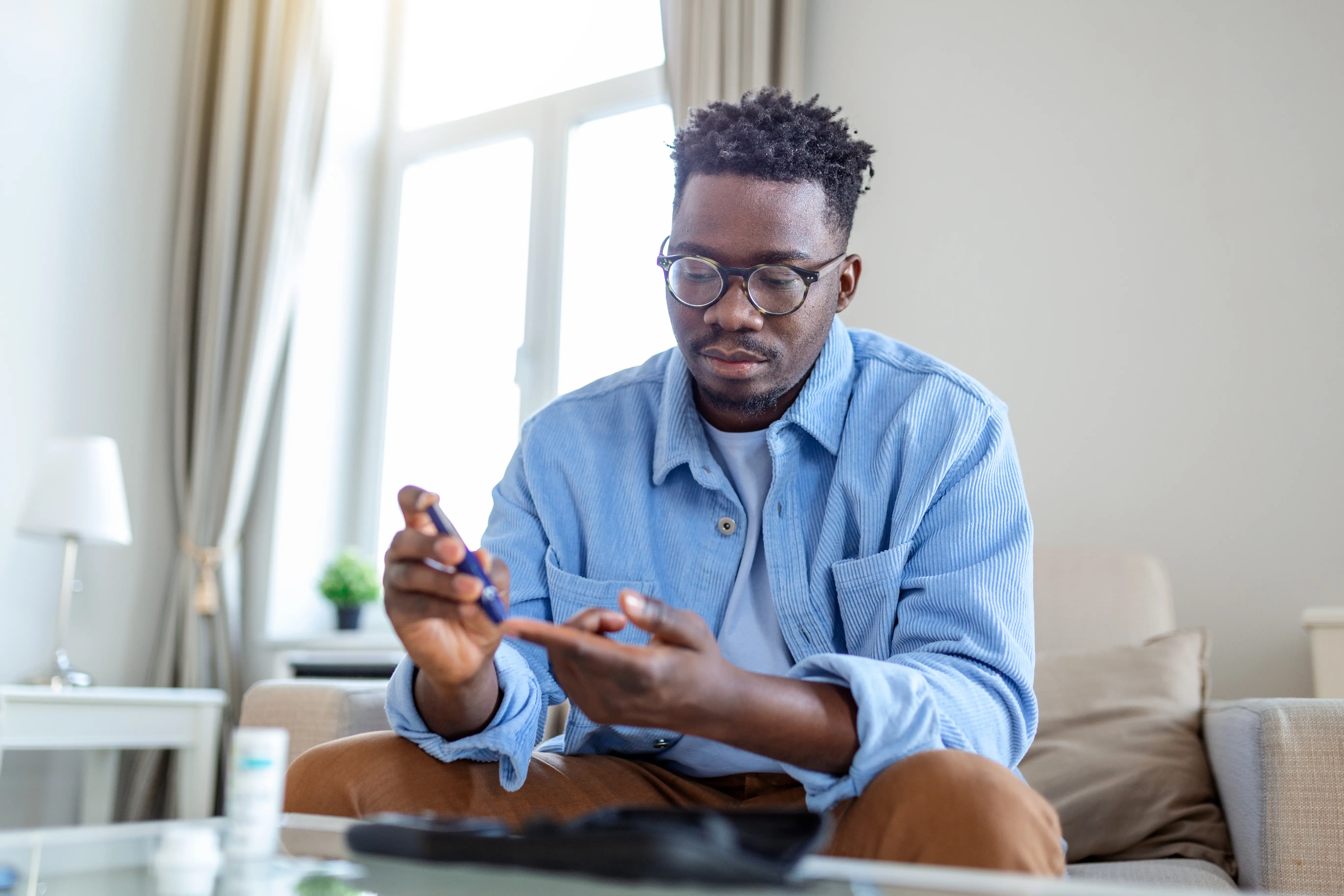 a man sitting on a couch holding a pen