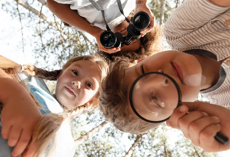 a group of kids looking through binoculars