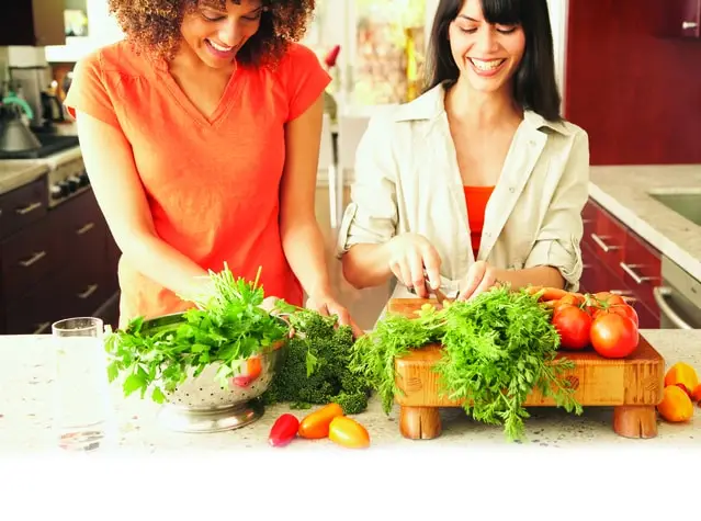 women in the kitchen cutting vegetables