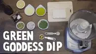 a blender with different colored food items on a table