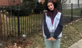 a woman standing in front of a fence