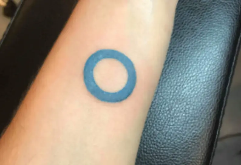 a blue circle tattoo on a person's arm