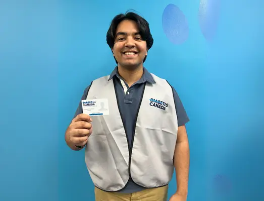 a man wearing a vest and holding a name tag