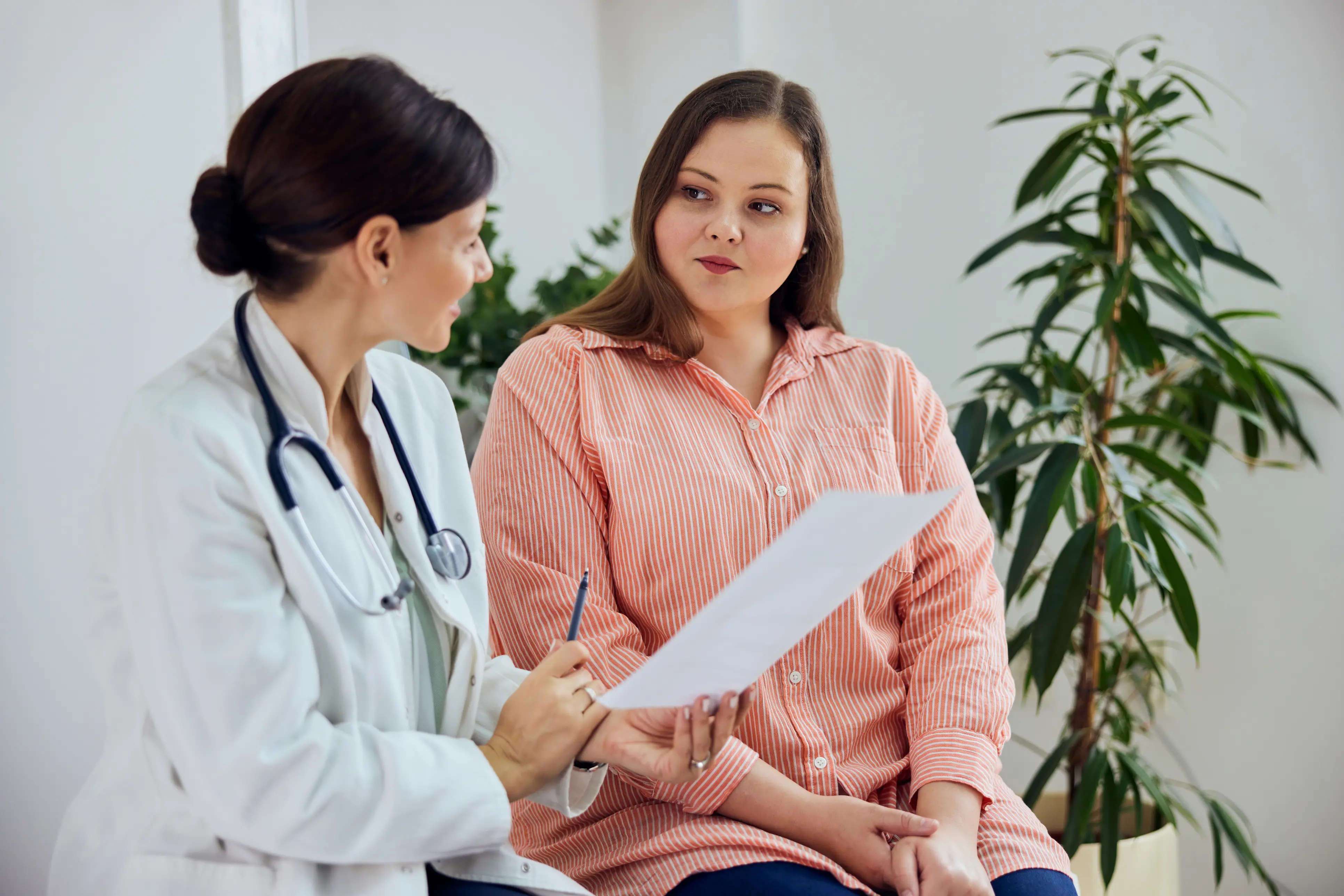a woman sitting next to a doctor