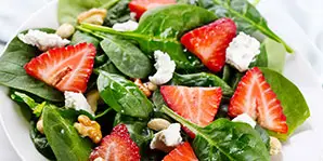 a salad with strawberries and spinach