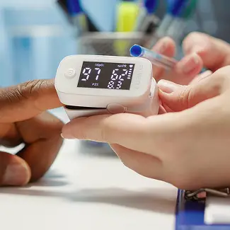 a person's hand holding a fingertip device