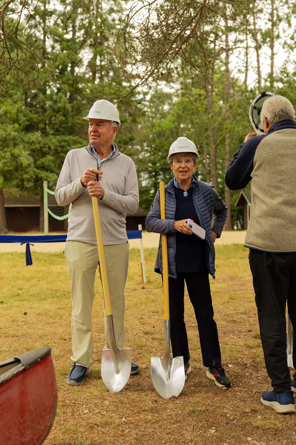 a group of people wearing hard hats holding shovels