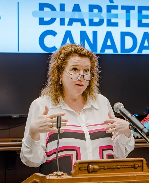 a woman standing at a podium with two microphones