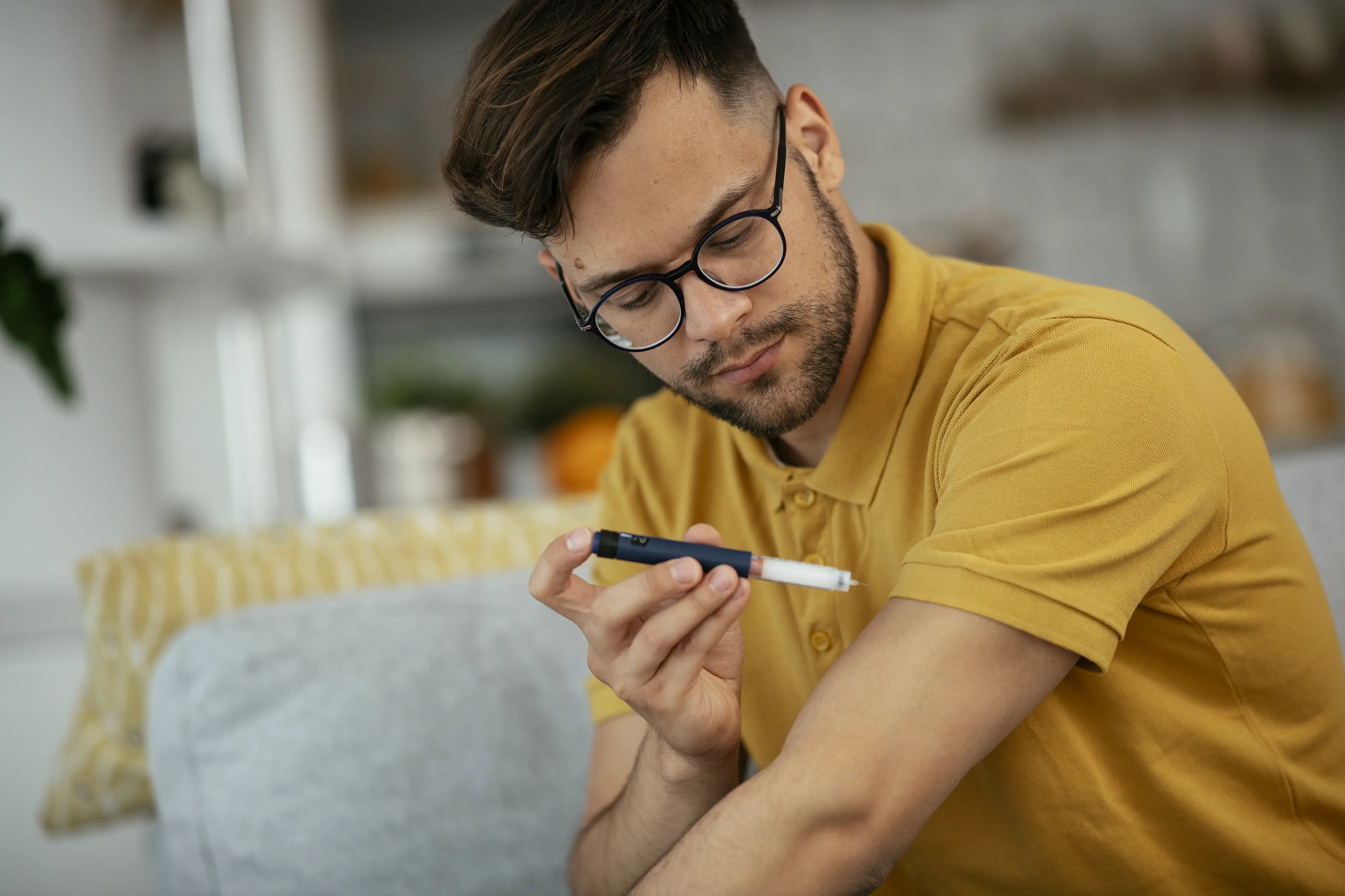 a man in glasses holding a pen