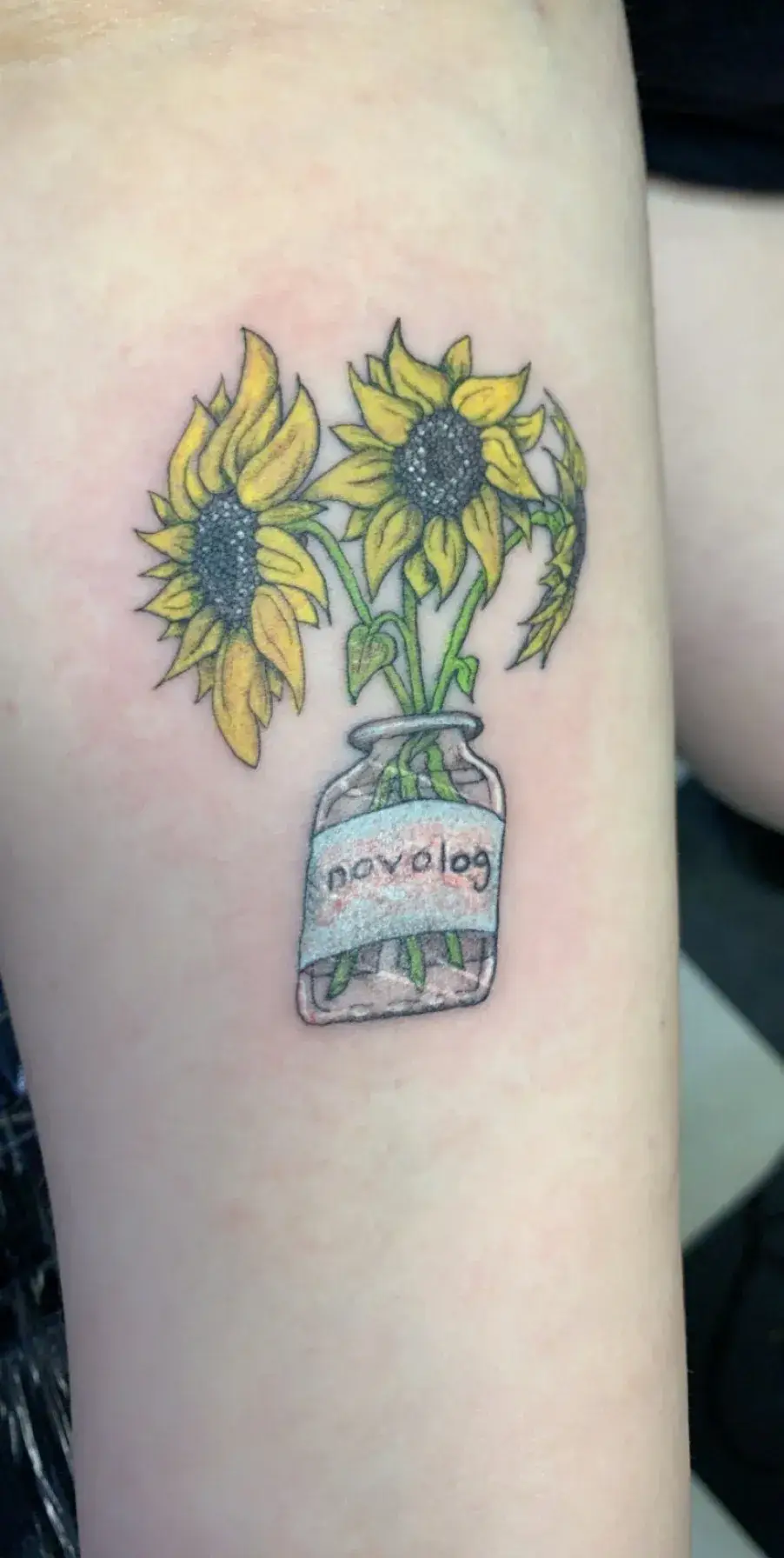 a tattoo of sunflowers in a jar