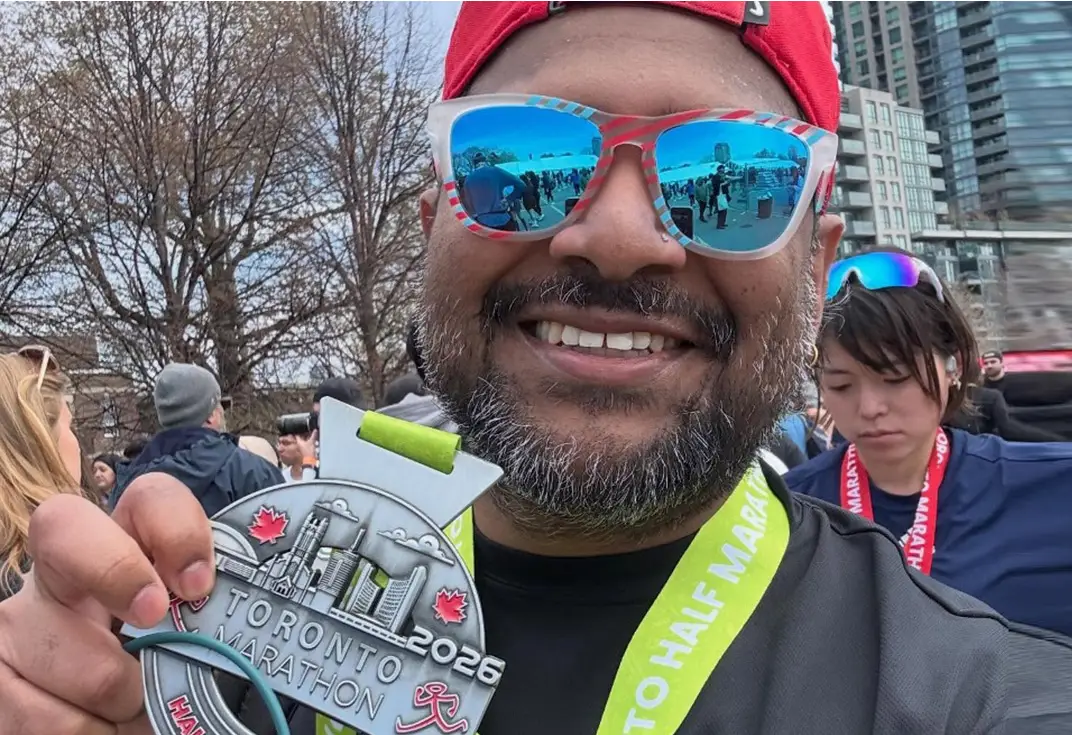 man in sunglasses holding a medal
