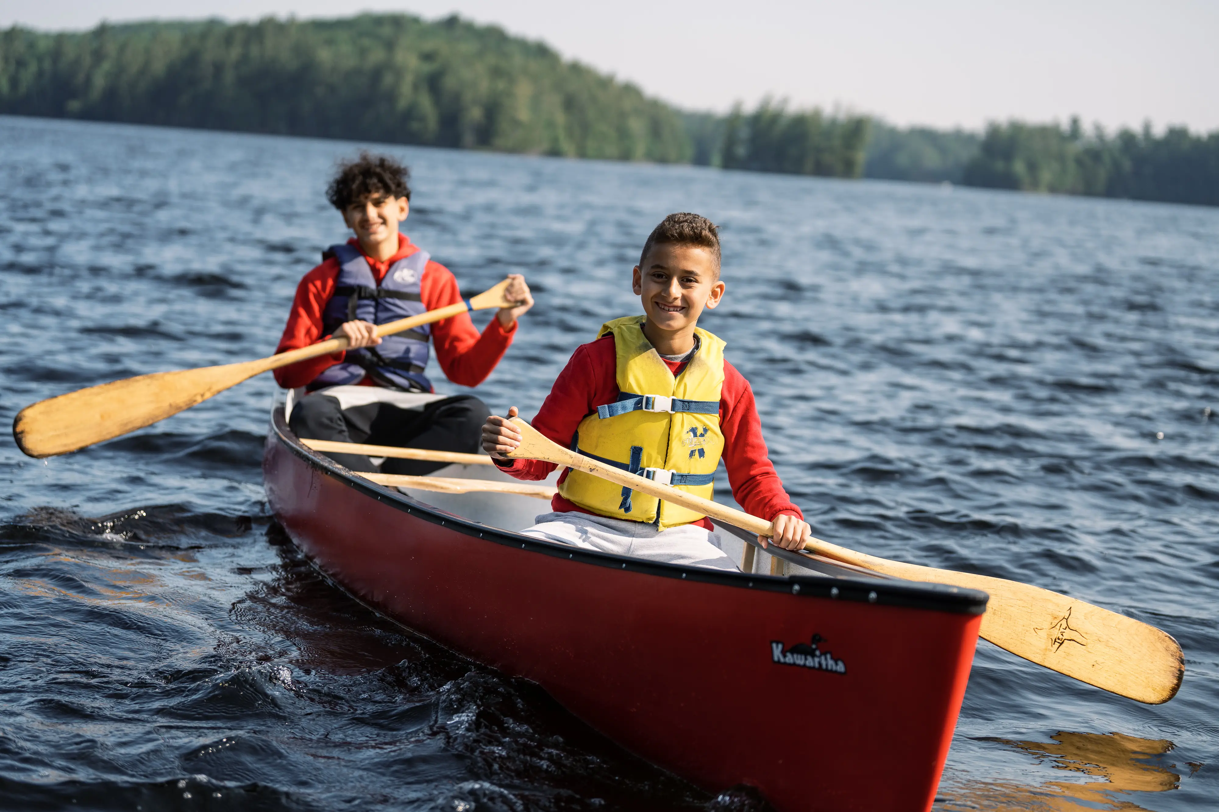 two boys in a canoe on a lake
