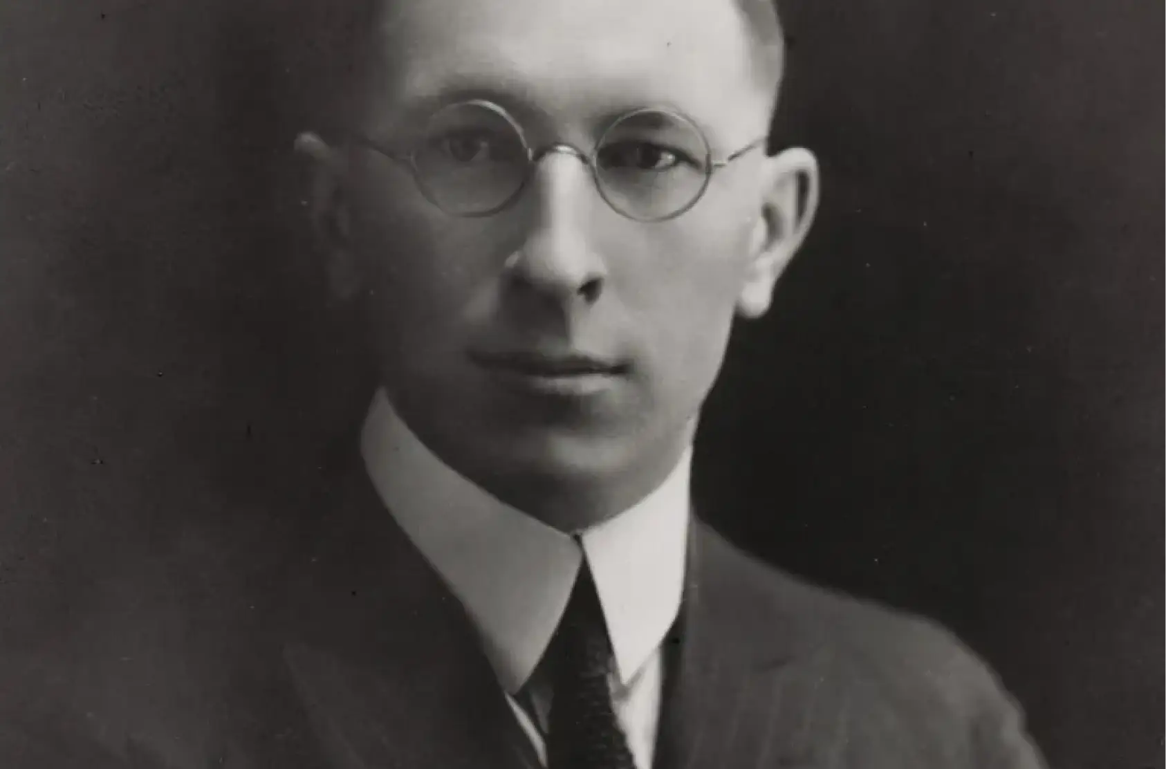 a man wearing glasses and a suit
