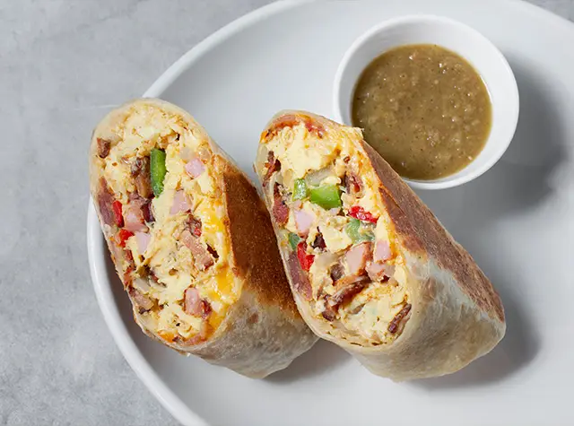 a burrito on a plate with a sauce