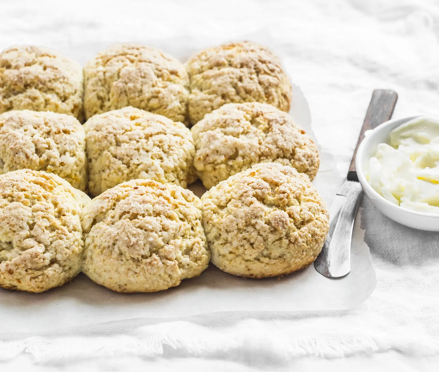 a plate of biscuits and a bowl of cream cheese