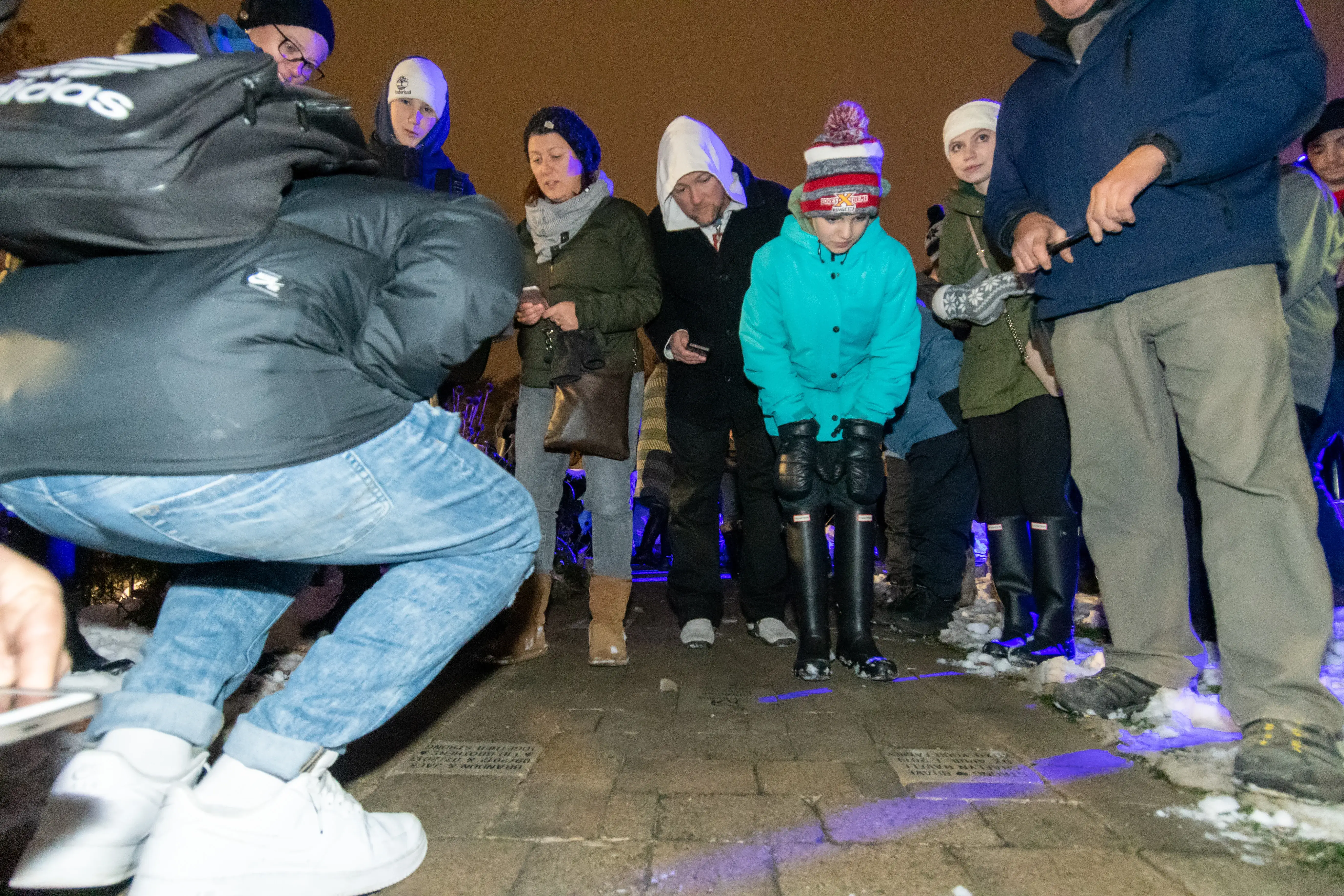 a group of people standing on a sidewalk