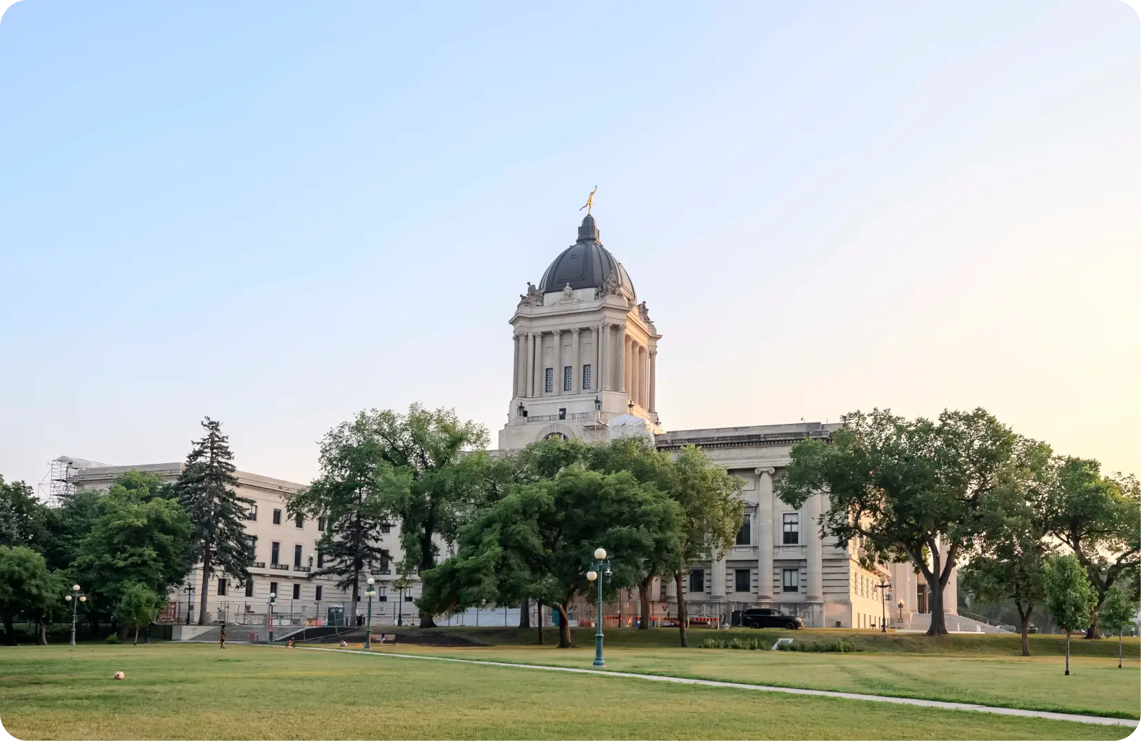 a large building with a dome and a lawn in front of it