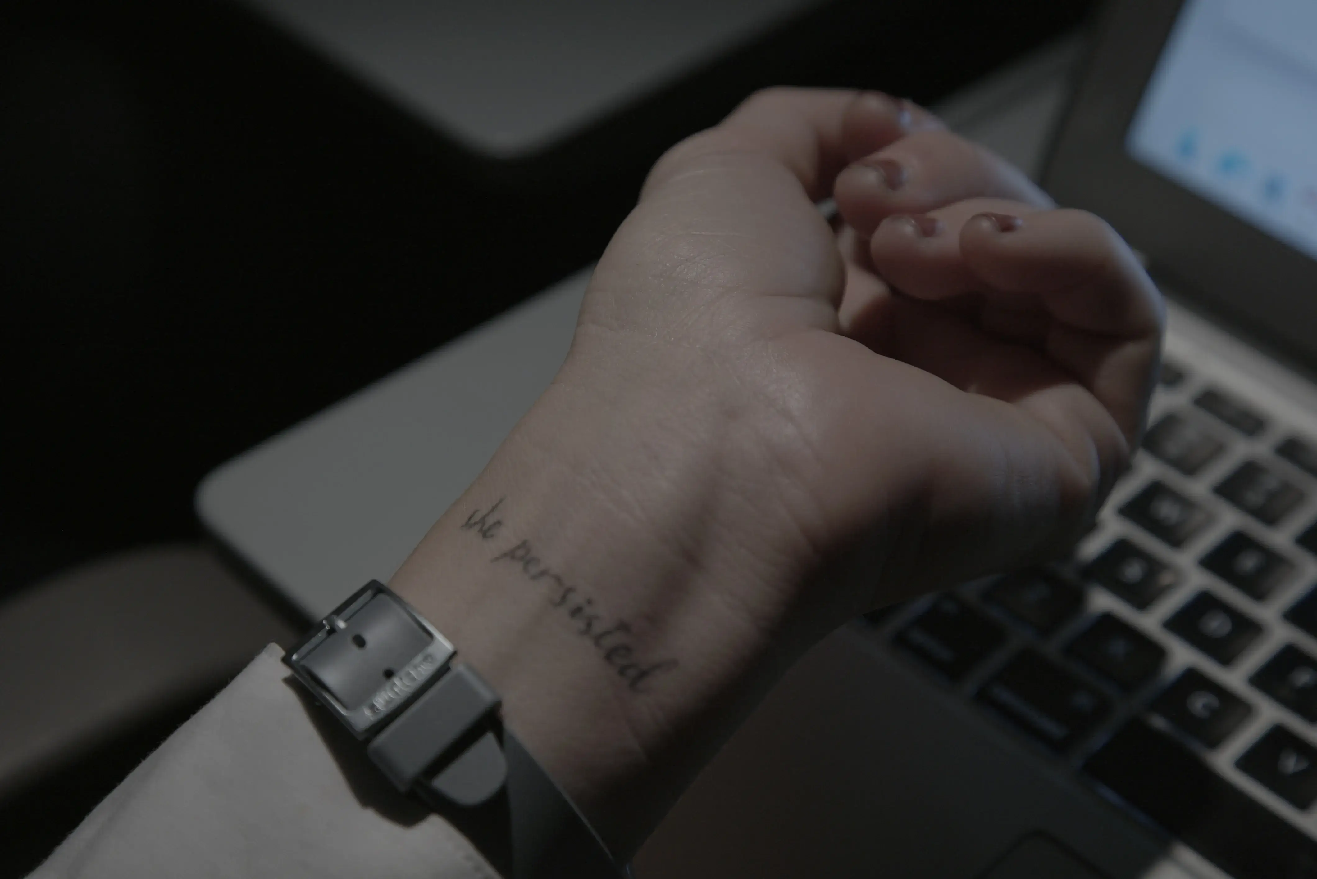 a wrist with a wristband and a wrist tattoo