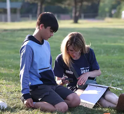 a woman and boy sitting on grass