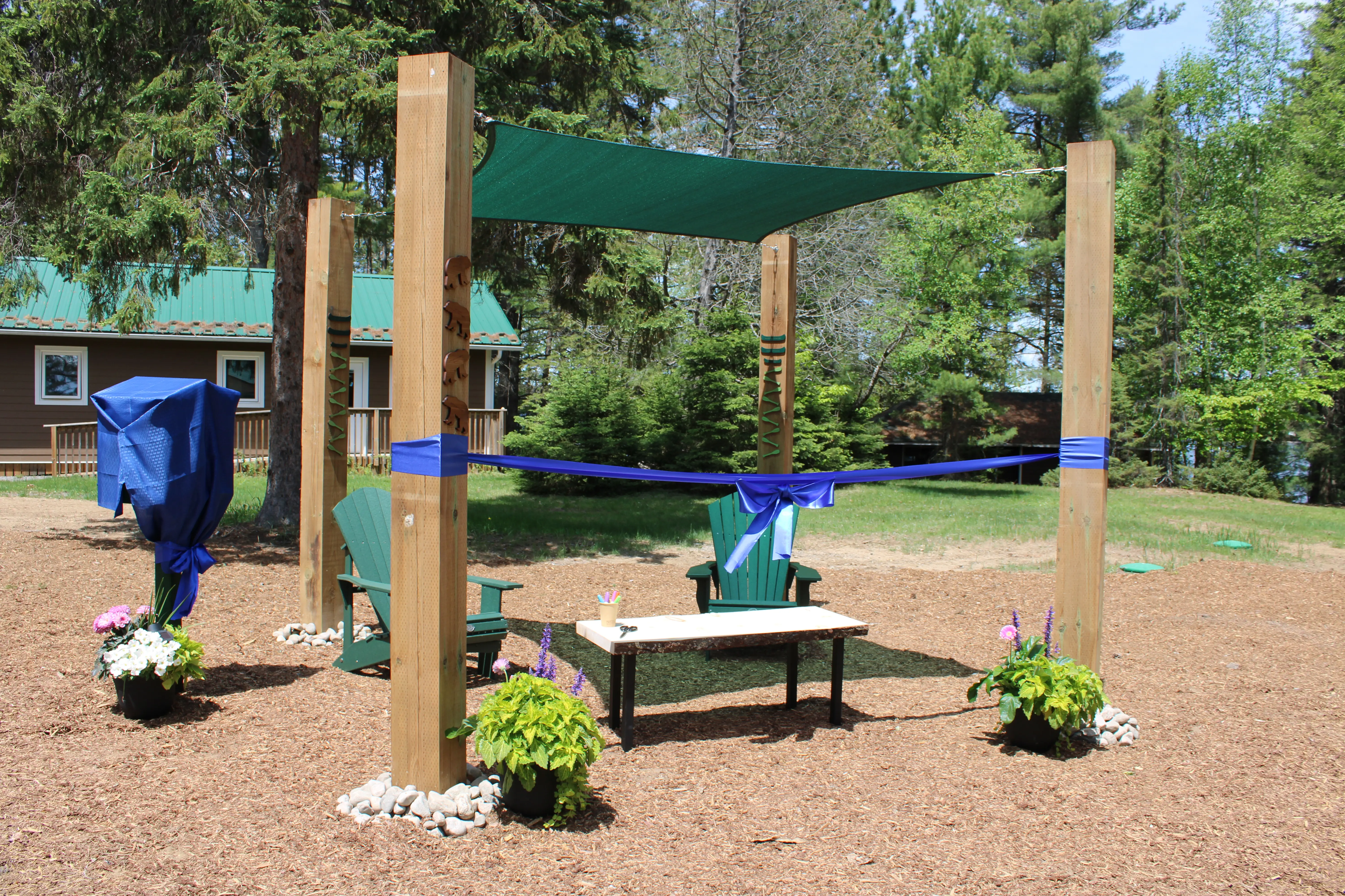 a wooden structure with a green shade and a bench