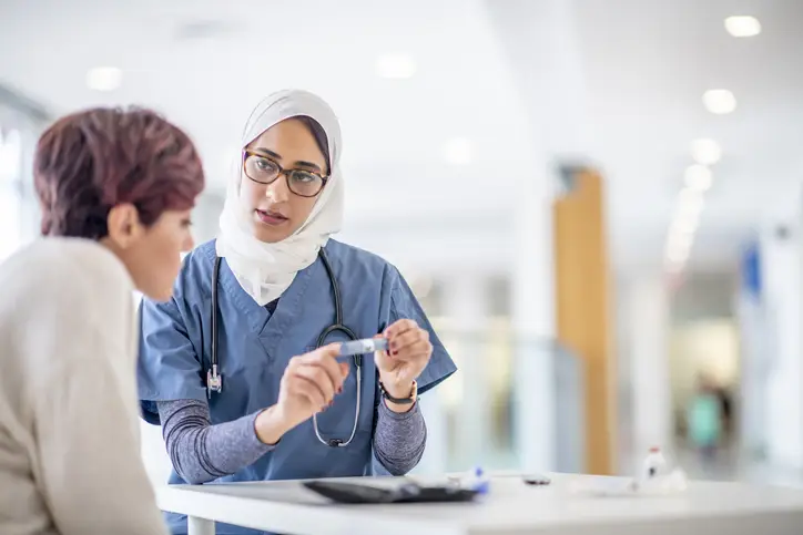 a woman in a headscarf holding a test tube to a woman
