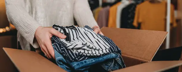 a person holding a stack of clothes