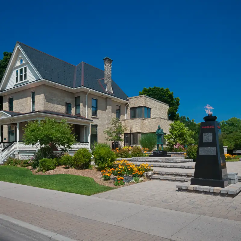 a large house with a monument in front of it