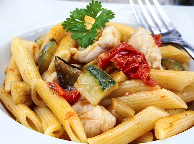 a plate of pasta with vegetables and meat