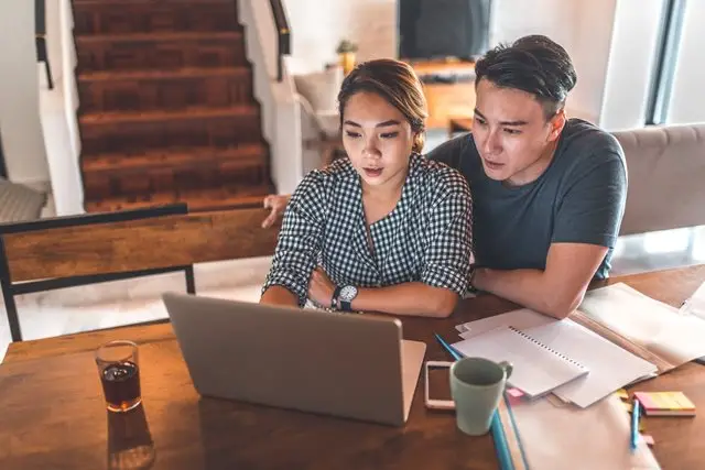 a man and woman looking at a laptop
