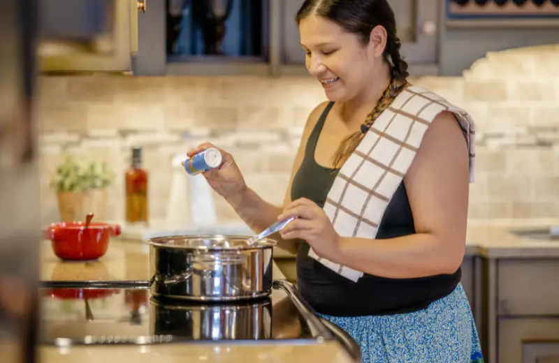 a woman cooking in a kitchen