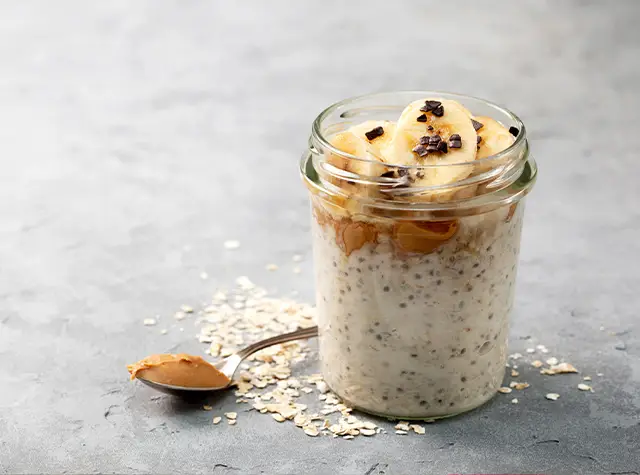 a jar of oatmeal with bananas and chocolate chips