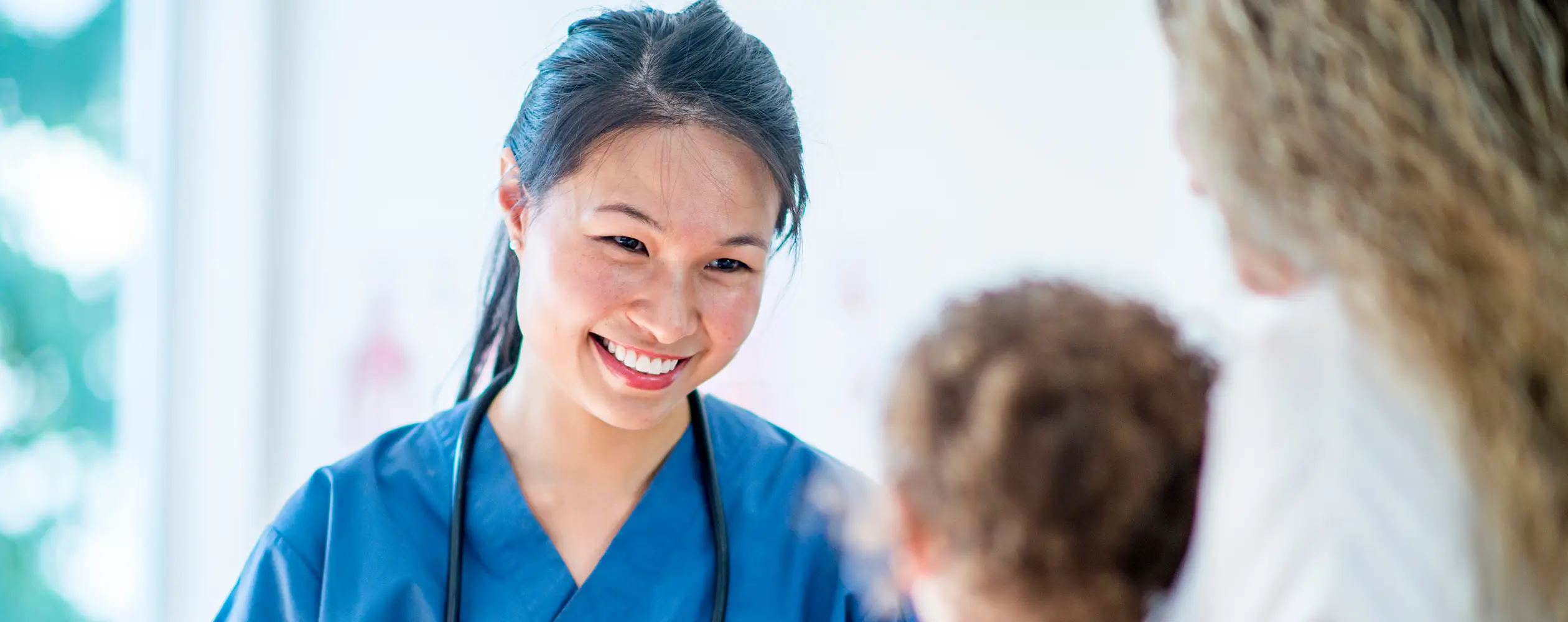 a woman in blue scrubs smiling