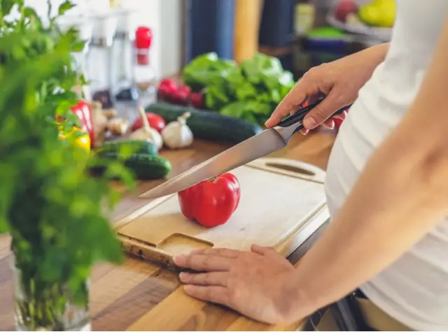 a person cutting a tomato