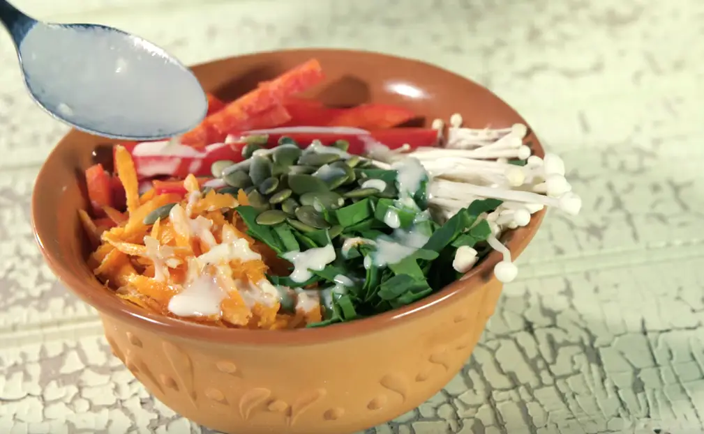 a bowl of vegetables and a spoon