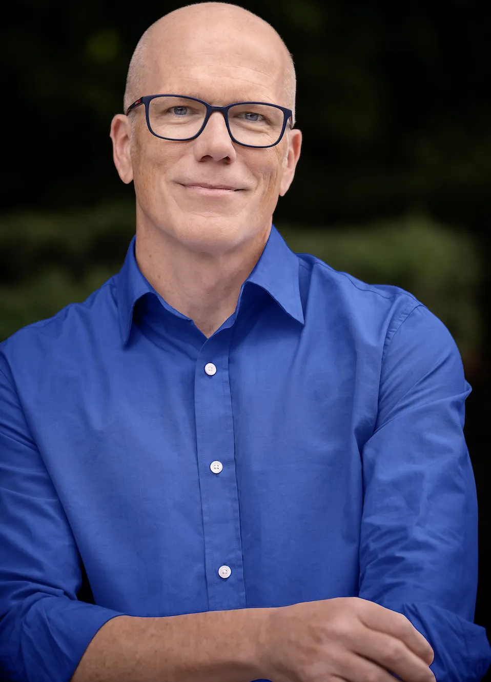 a man wearing blue shirt and blue glasses