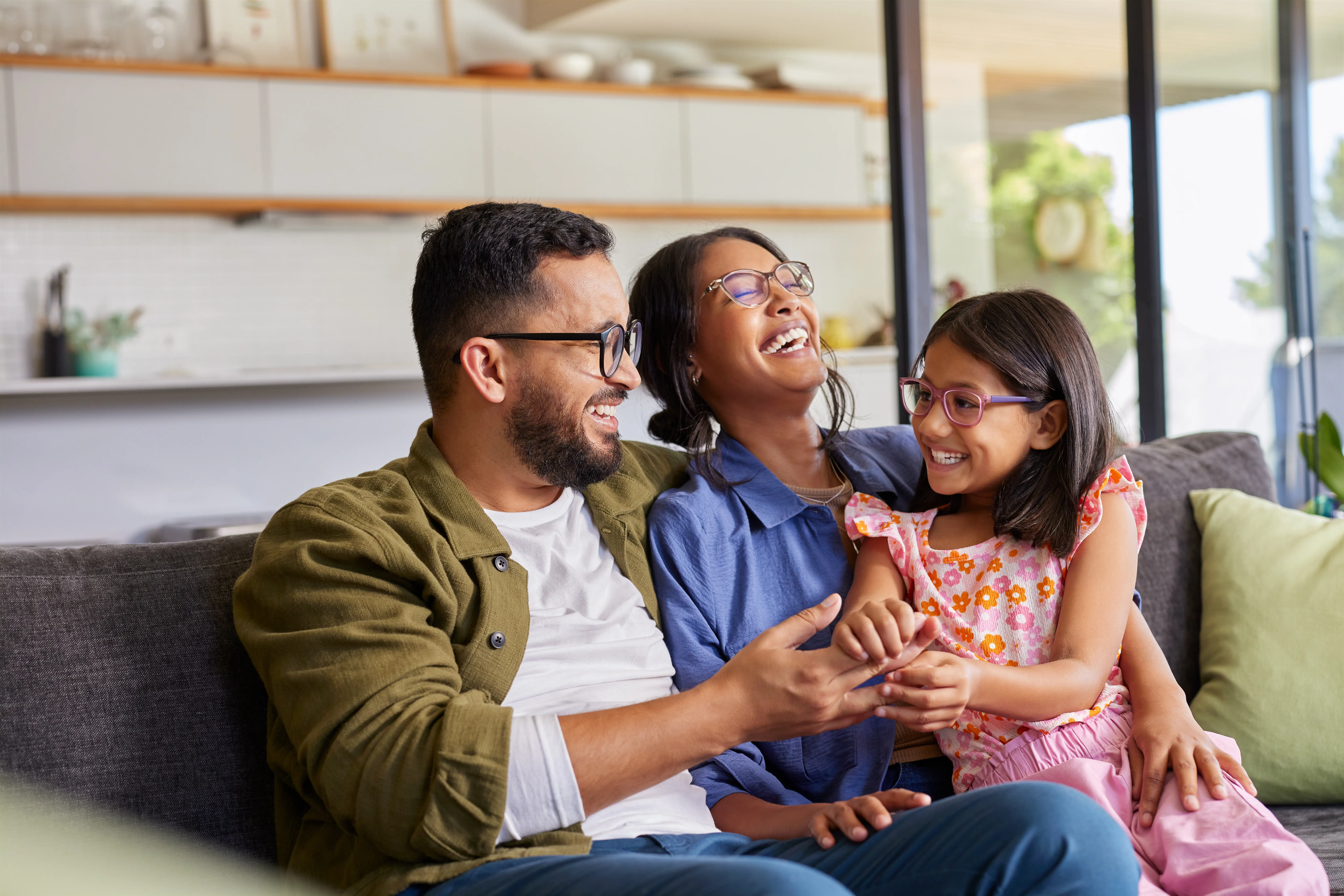 a man and woman sitting on a couch with a child