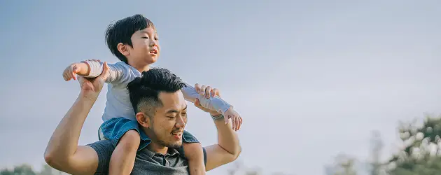 a man carrying a child on his shoulders